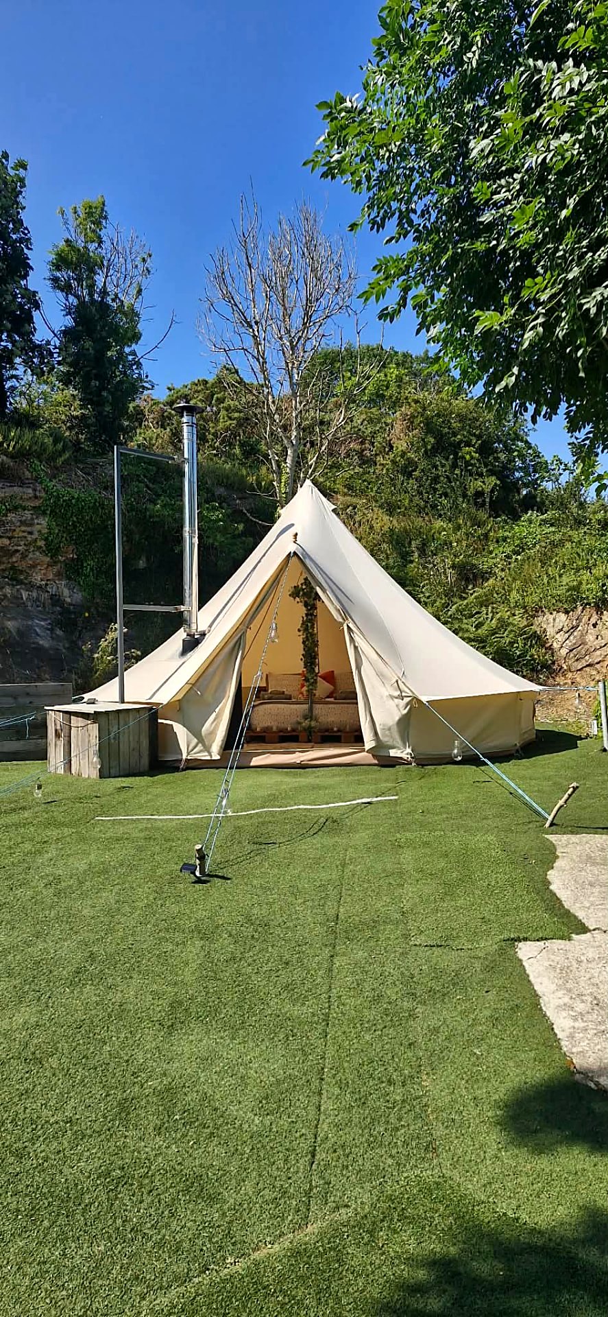 Fairy Cove bell tent open to the lawn in daylight with cushioned seating inside