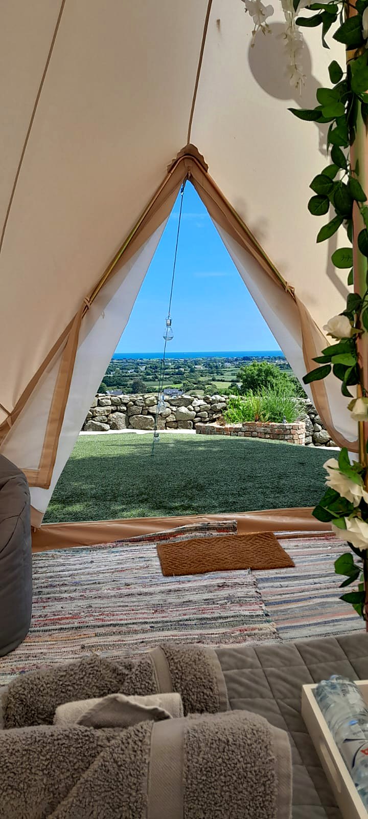 The view from inside Fairy Fort through the open doorway across the lawn and fields to the sea