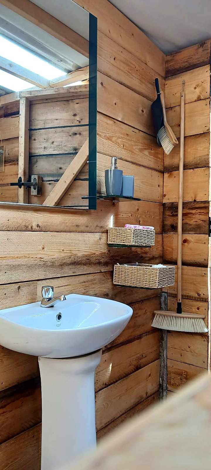 Timber-lined washroom at Fairy Fort with basin, mirror and fresh towels
