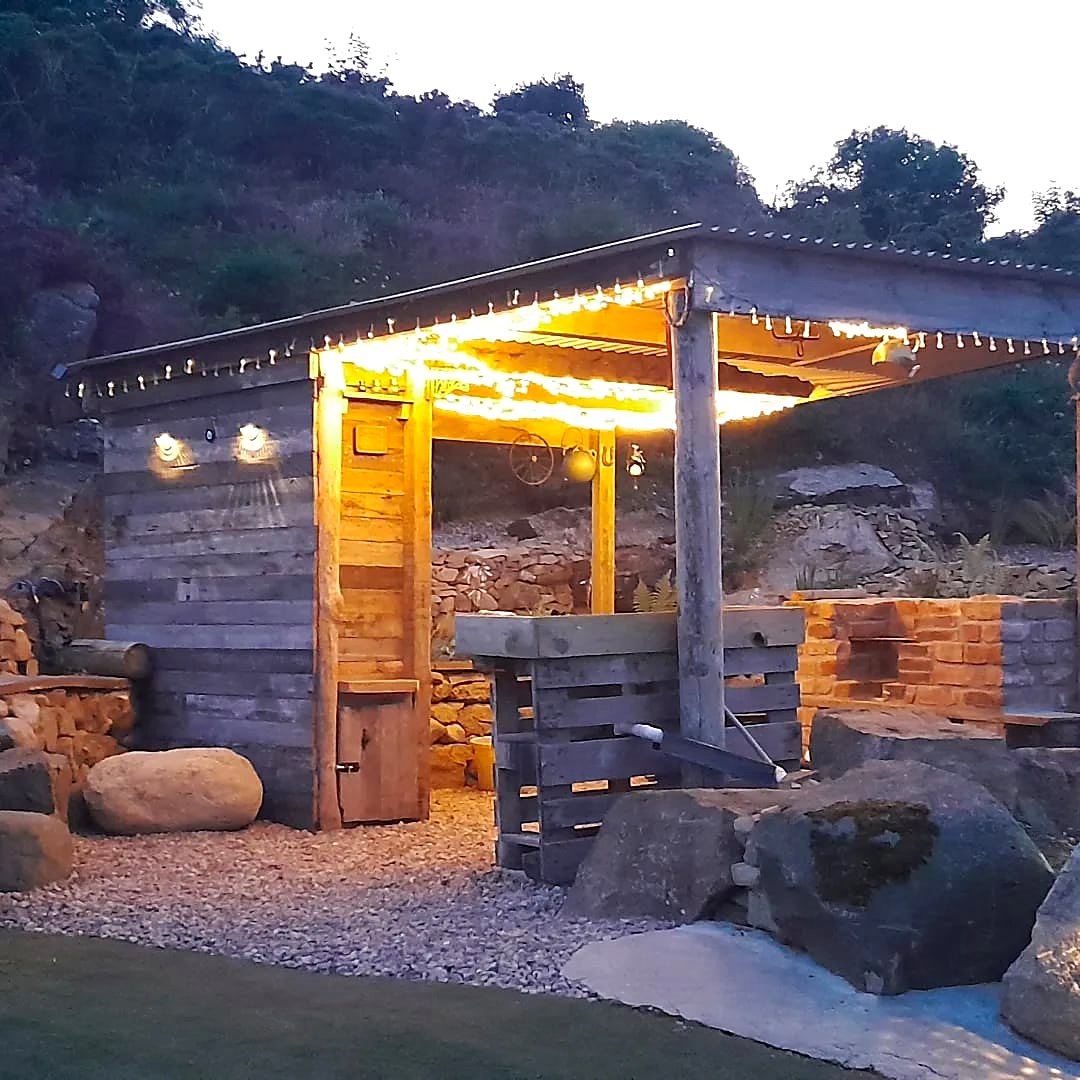Fairy Hill's timber shelter glowing with fairy lights in the evening