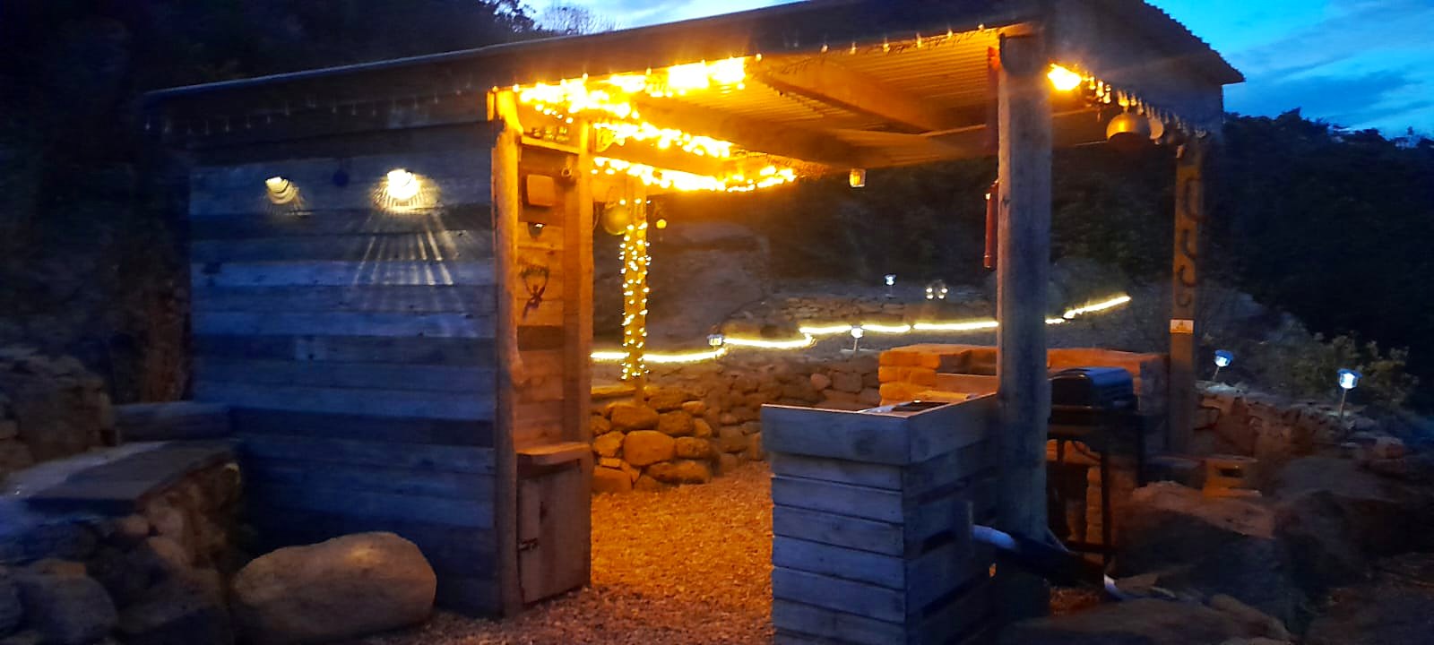 Fairy Hill's cooking shelter lit with warm lights after dark